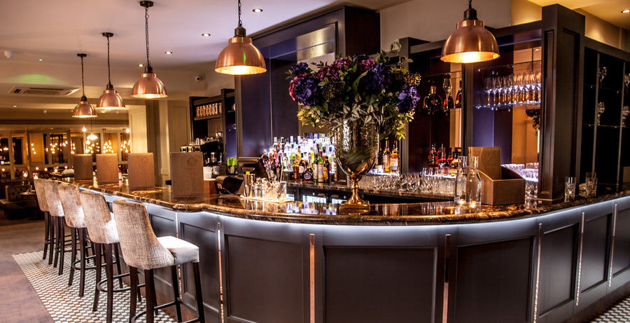 Velvet stools and industrial lights in a bar interior