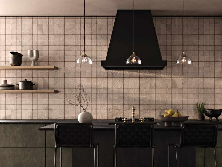 Industrial style kitchen with white tiled walls and 3 glass pendants above a dark green kitchen island