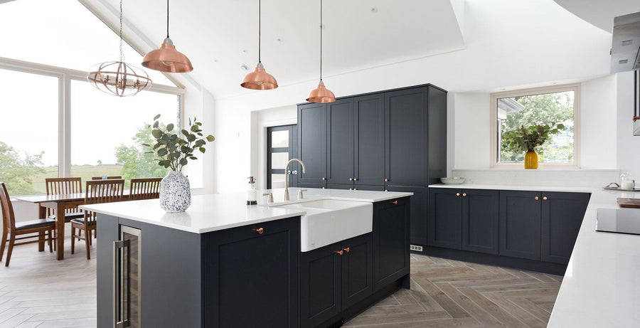 Dark kitchen interior with trio of copper pendants above kitchen island