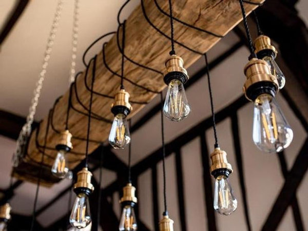 Exposed bulbs hanging over a wooden beam