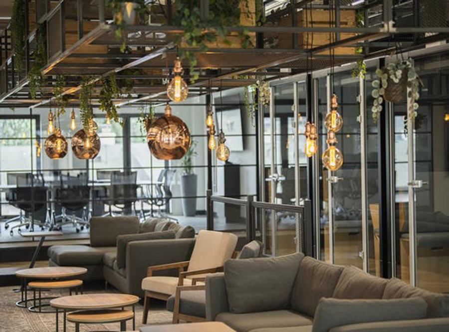 An industrial style office space with numerous pendant lights