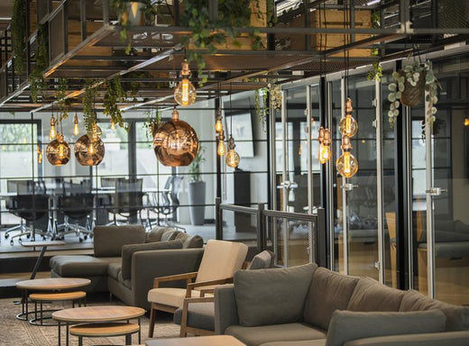An industrial style office space with numerous pendant lights