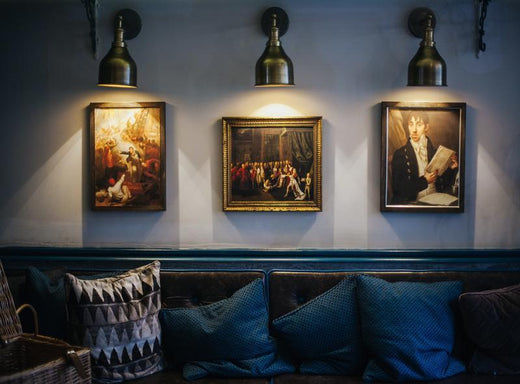 Industville wall lights shining over paintings in a hotel 