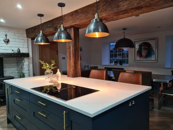 Brooklyn lights in a row of three hanging over a kitchen island  