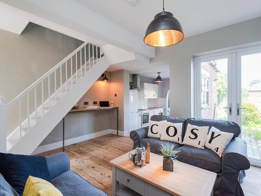A cosy living room with blue furniture and brick fireplace
