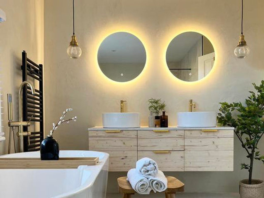 Two backlit mirrors with pendant lights on either side. 