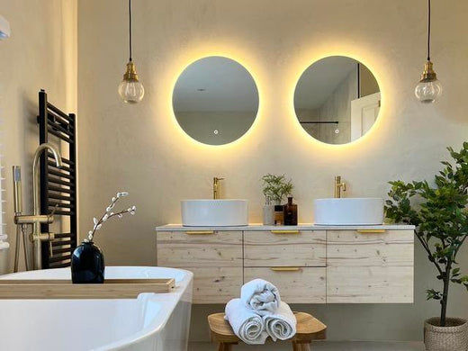 Two backlit mirrors with pendant lights on either side. 
