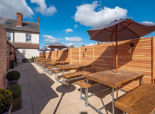 An outdoor dining area with benches and parasols 
