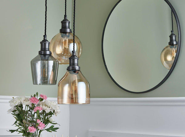 Three Industville tinted glass shades hanging over a table