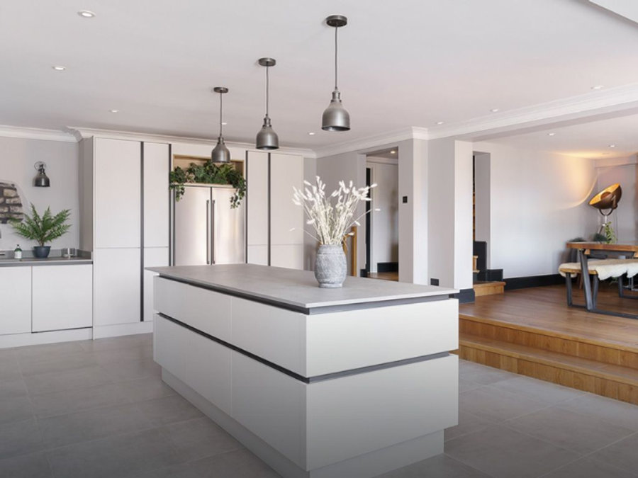 A modern kitchen and dining room space with pendant lights.