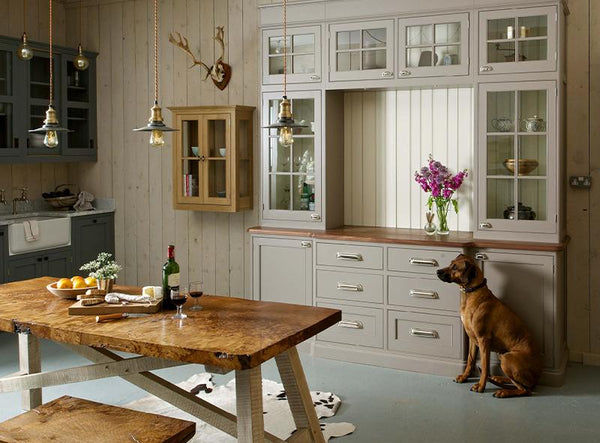 Neutral coloured kitchen interior with dog and trio of flat industrial pendants