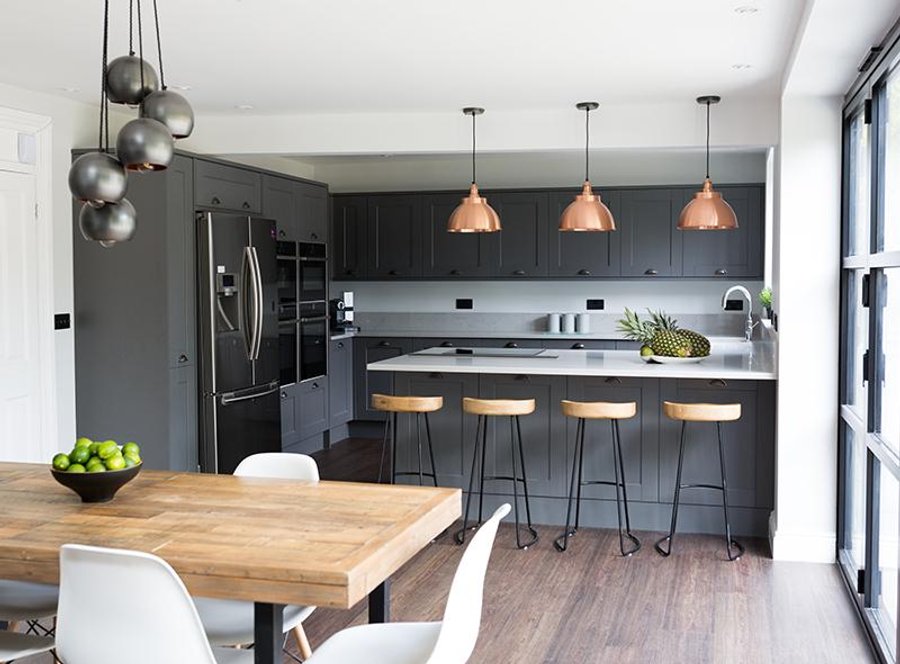 Grey open-plan kitchen interior with industrial lights