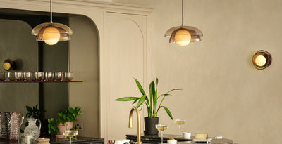 Contemporary home bar with twin mocha glass pendant lights above a black island, paired with round mocha glass wall lights for layered ambient lighting.