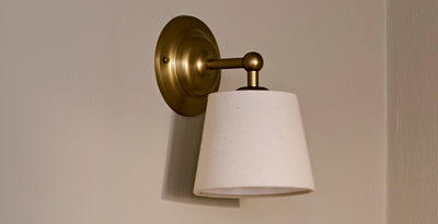Vintage and retro wall light with a brass fixture and fabric shade, perfect for adding timeless charm to a hallway or kitchen.