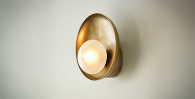 Brass wall sconce with frosted glass globe, a stylish and functional choice for modern bathroom lights.