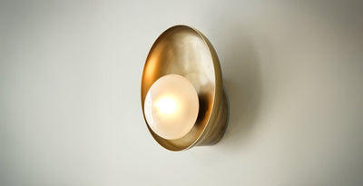 Brass wall sconce with frosted glass globe, a stylish and functional choice for modern bathroom lights.