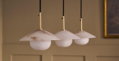 Trio of alabaster pendant lights with brass fittings, bringing a warm and elegant glow to a modern interior.
