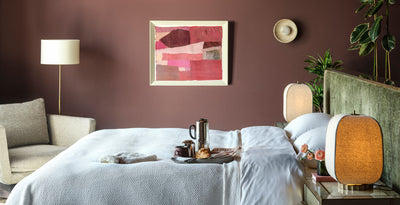 Modern bedroom lighting with matching fabric bedside table lamps and a floor lamp, creating a warm and inviting atmosphere against rich coloured walls.