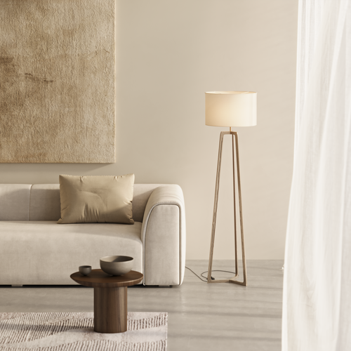 Brass floor lamp, wool pouffe, natural travertine wall light in a natural beige bedroom setting