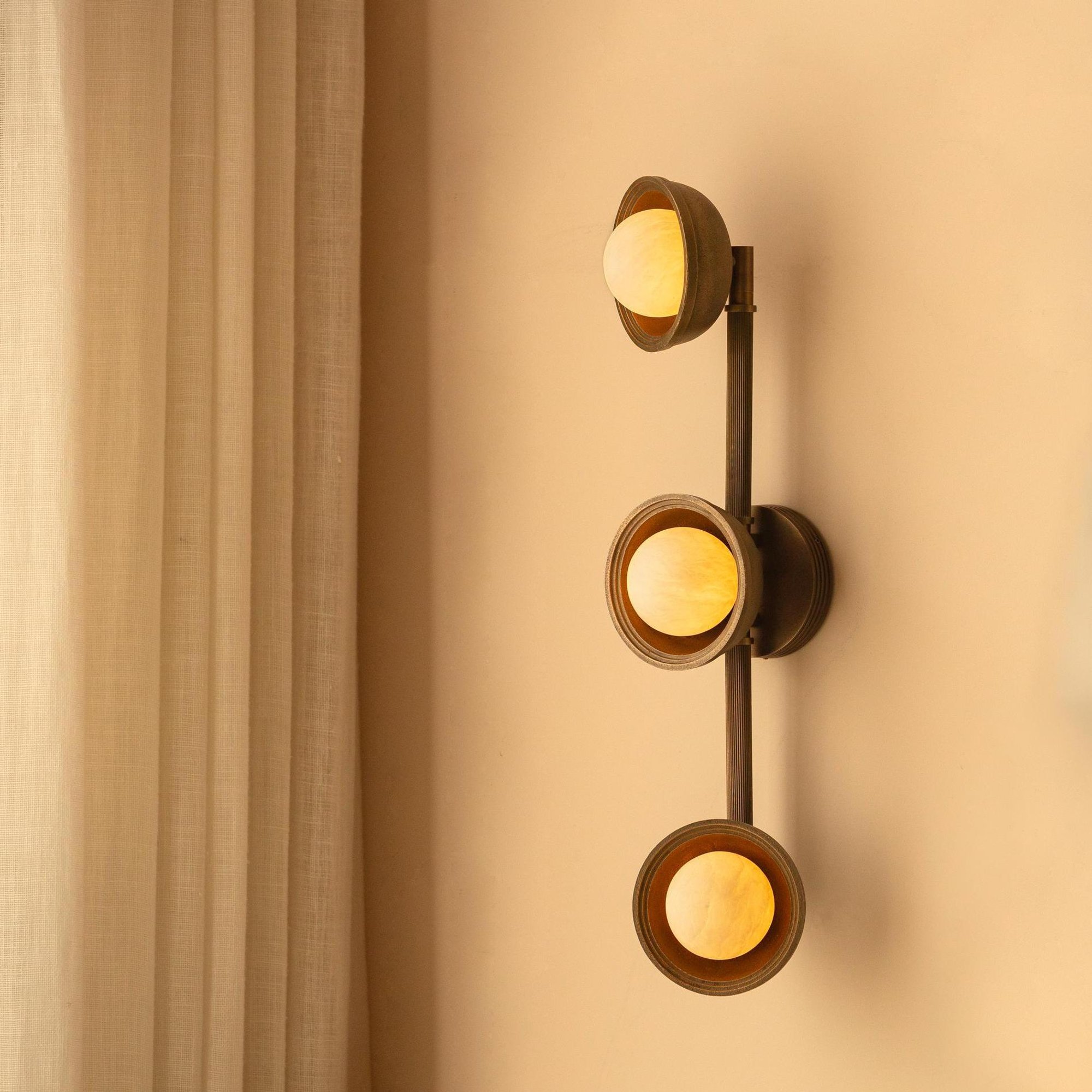 Corby Cast & Alabaster Triple Wall Light in Aged Brass lit up