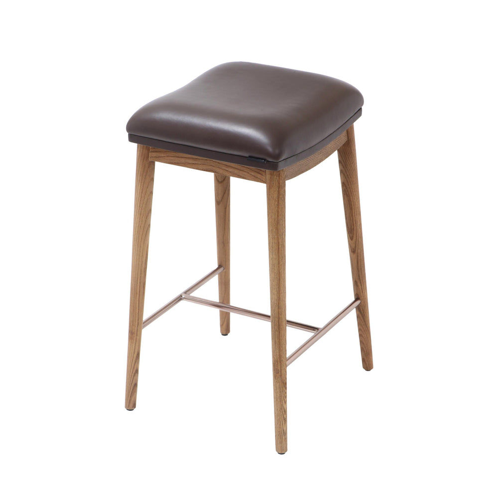 Counter height stool with natural ash wood legs, brown soft leather seat, and brushed metal footrest, angled view