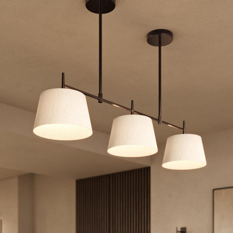 Bronze Henley Triple pendant with natural cotton shades lit on in the living room 