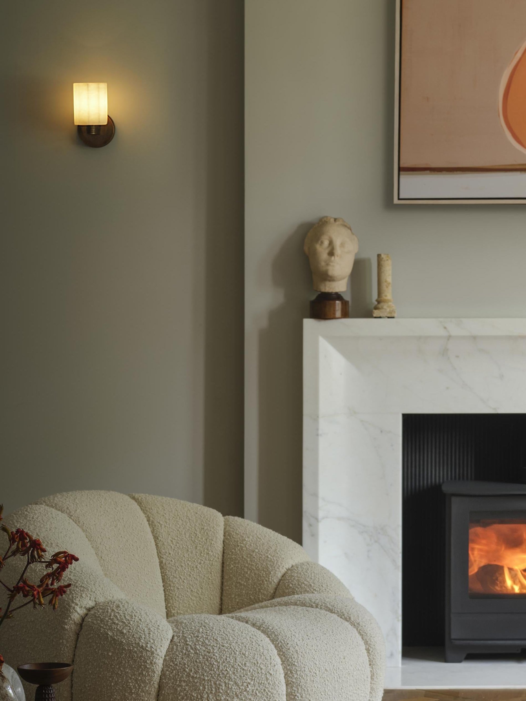 Corby Cast Alabaster Fluted Wall Light in 4 Inch in Aged Brass Finish Lit Up in a Living Room