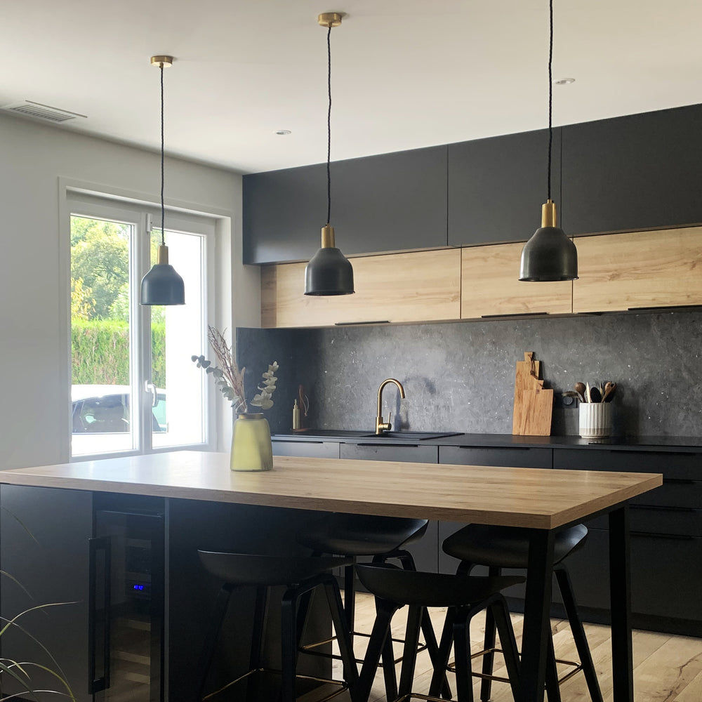 Brass sleek cone pendant in a dark kitchen